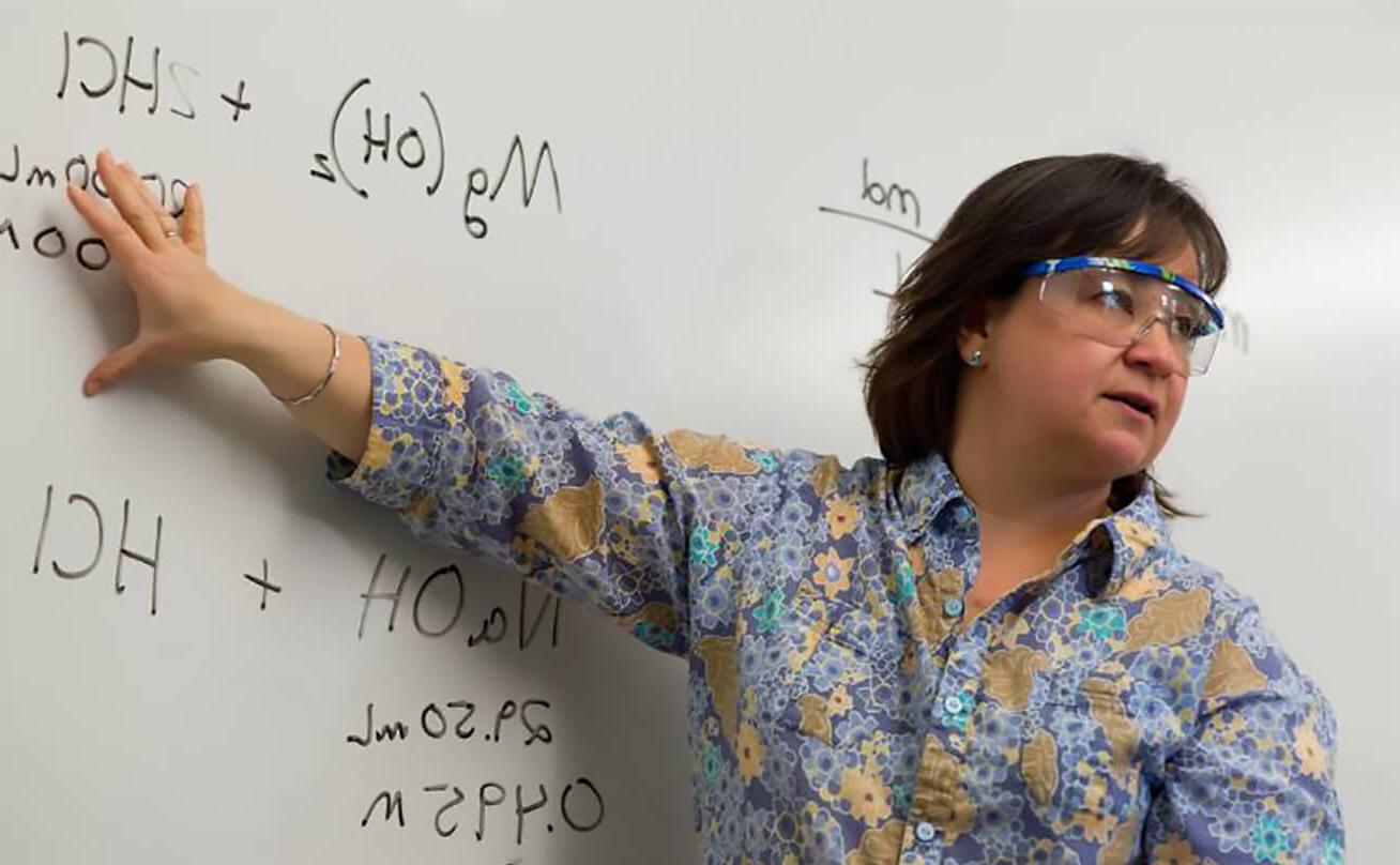 Woman with goggled pointing to whiteboard